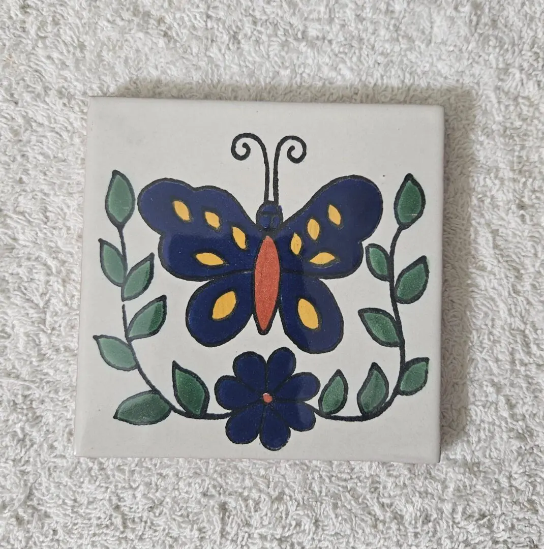 Colorful butterfly and flower on decorative tile.