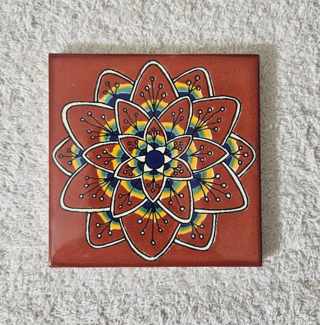 Colorful mandala pattern on a square tile.