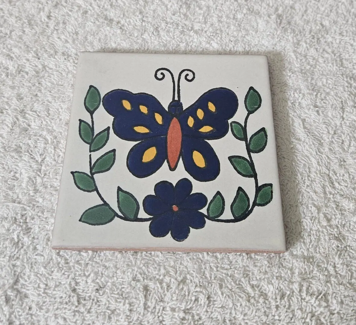 Tile with butterfly and flower design.