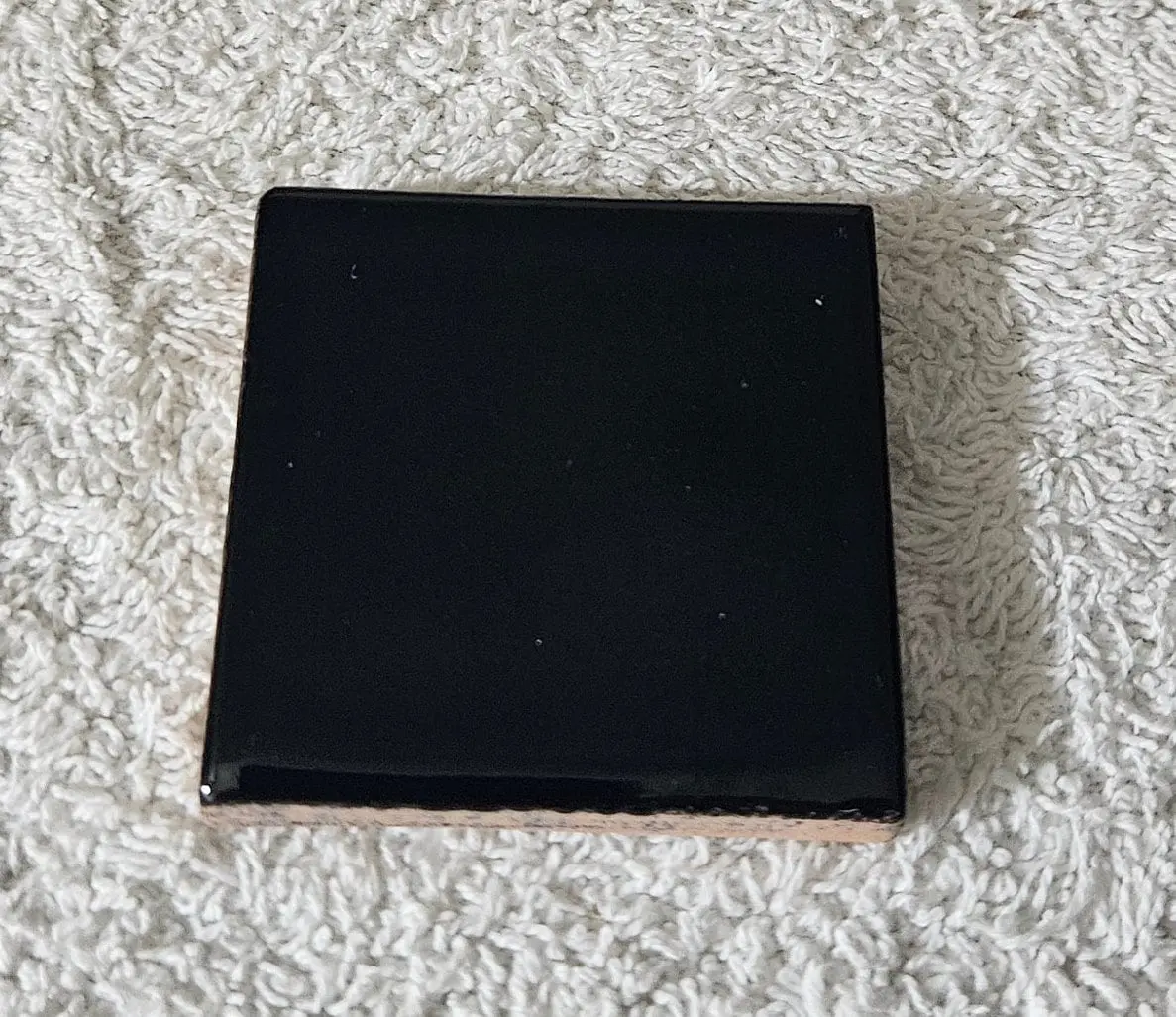 Black square box on a textured surface.