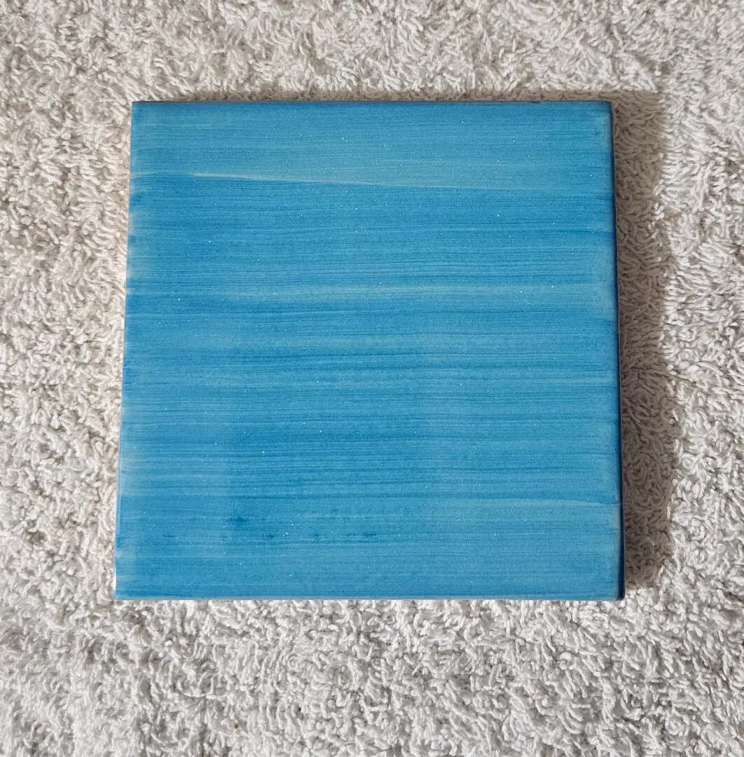 Blue painted square on textured surface.