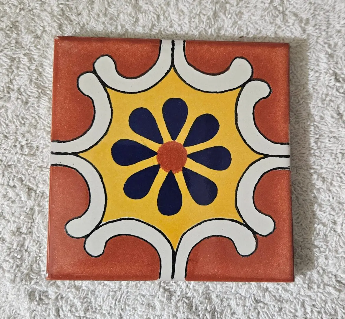 Hand-painted ceramic tile with navy flower