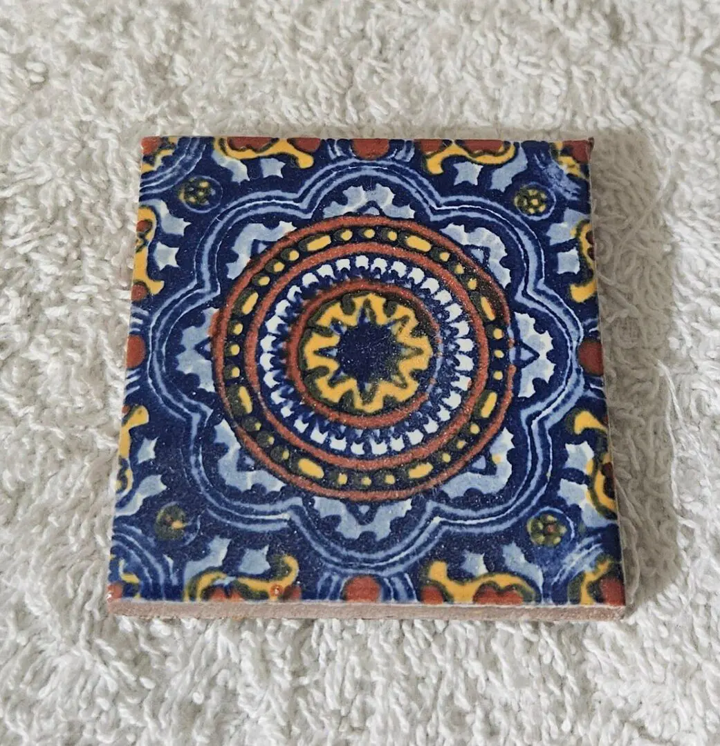 Ceramic tile with intricate blue and orange pattern.