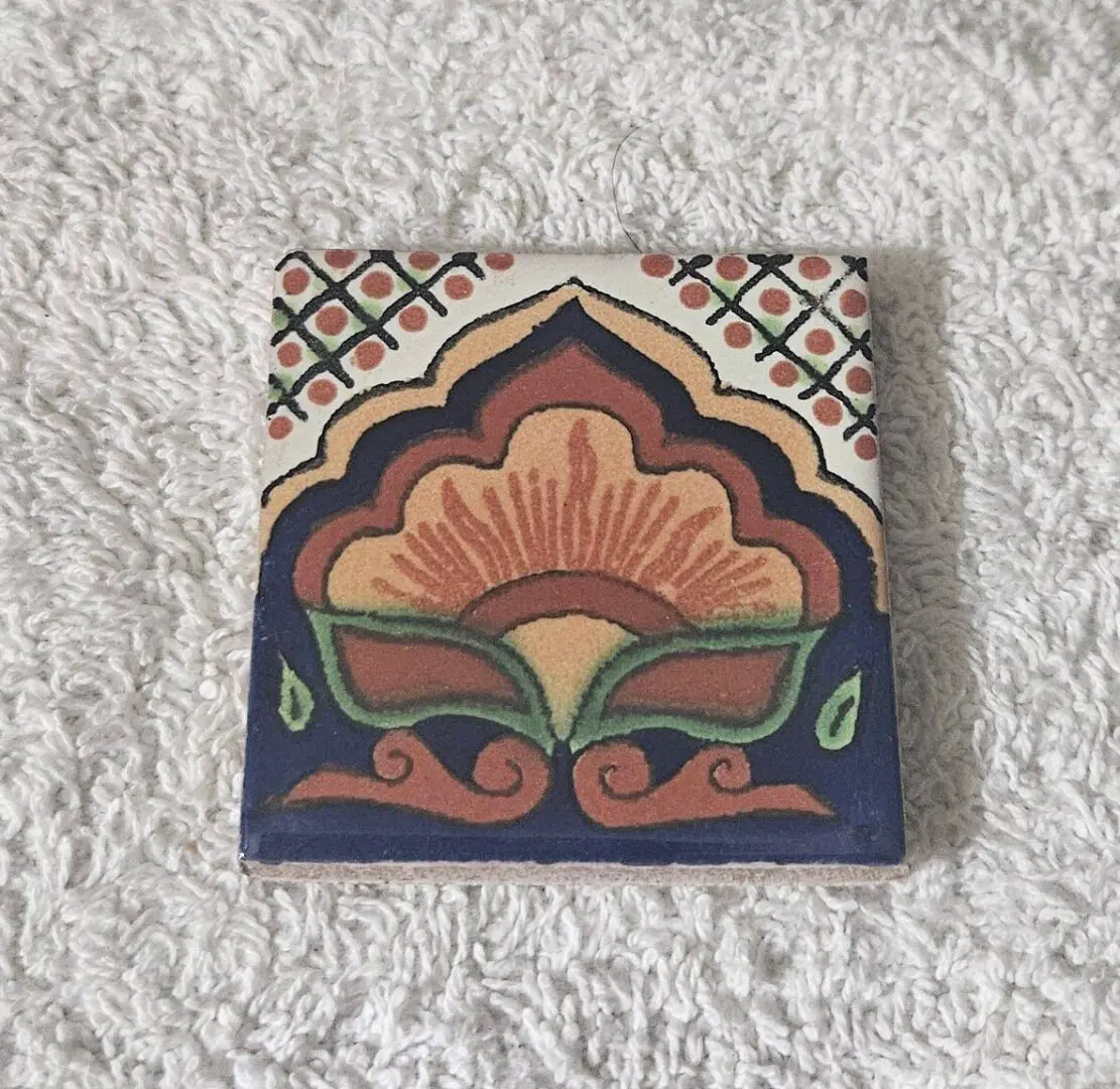 Decorative floral ceramic tile on white cloth
