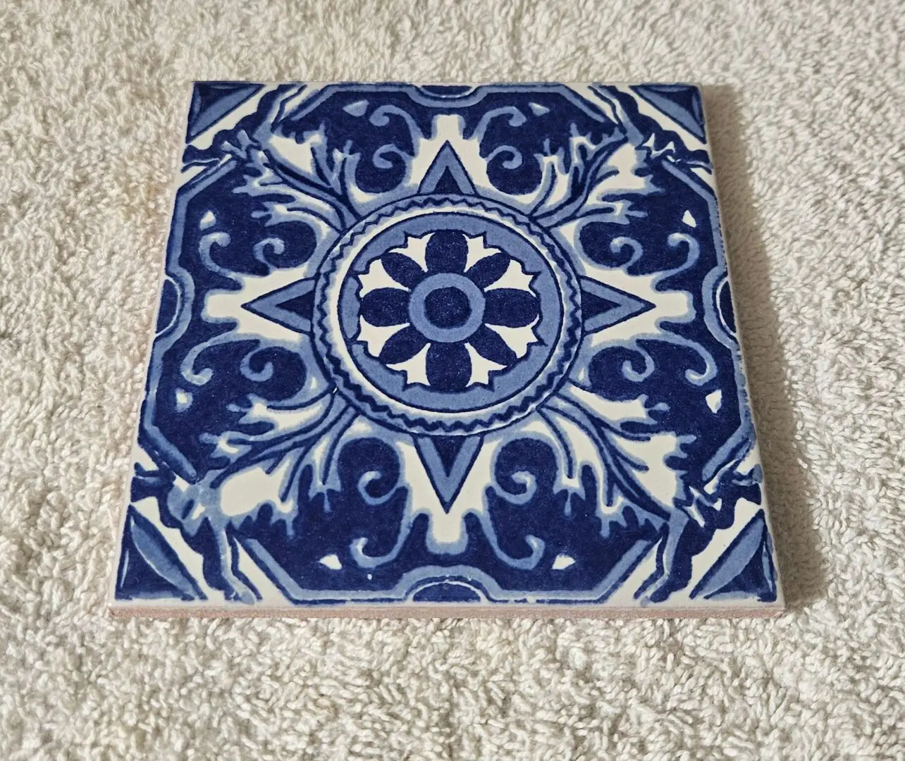 Blue and white decorative ceramic tile on towel