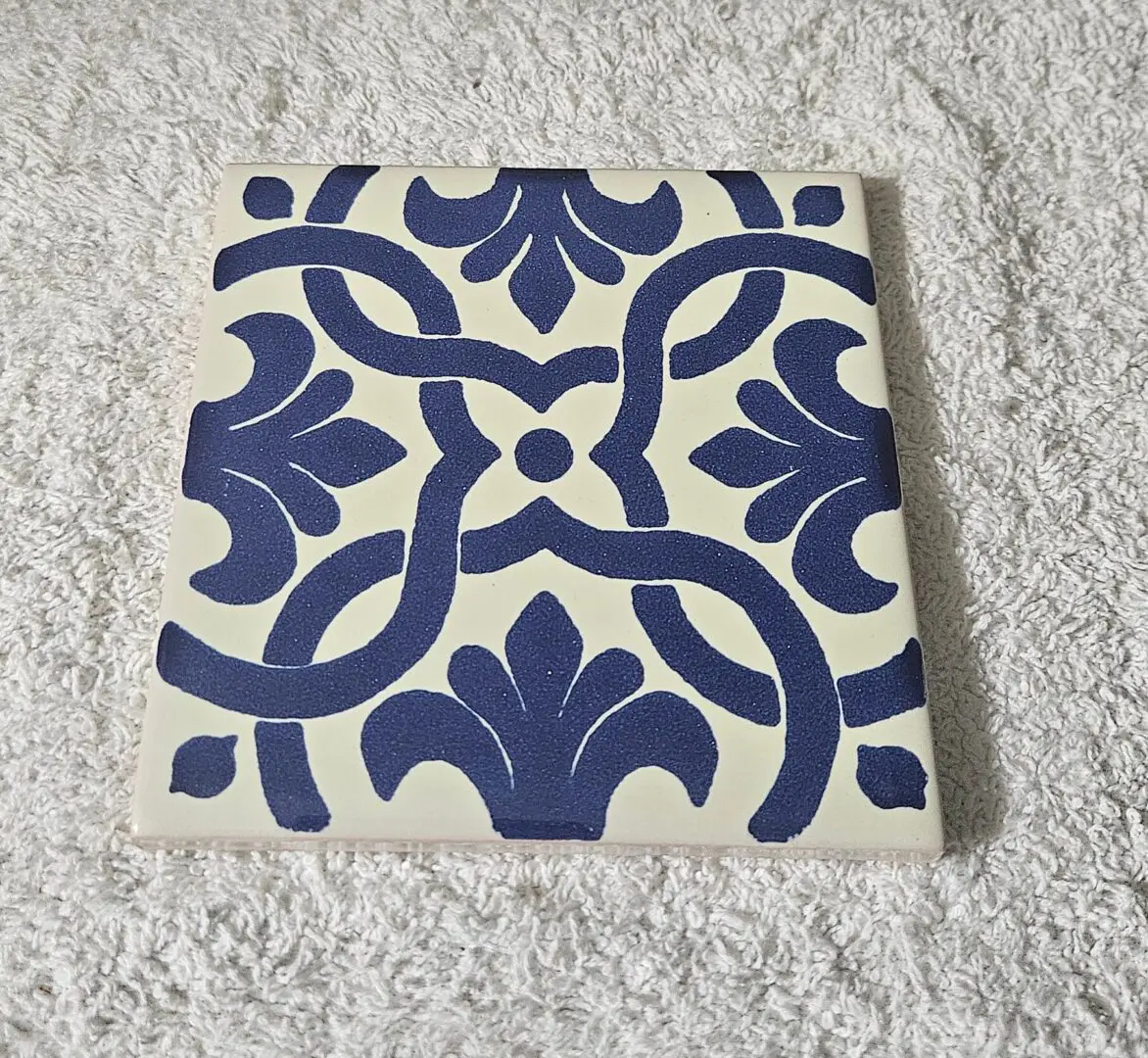Navy blue patterned ceramic tile on towel