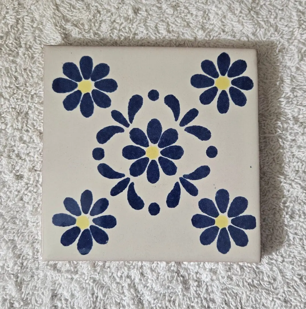 Blue floral pattern on square ceramic tile.