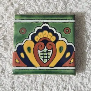 Colorful decorative tile with intricate floral pattern on textured surface.