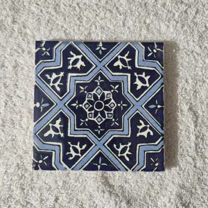 Blue geometric patterned ceramic tile on fabric.