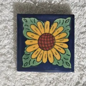 Hand-painted sunflower tile with green background and decorative leaves.