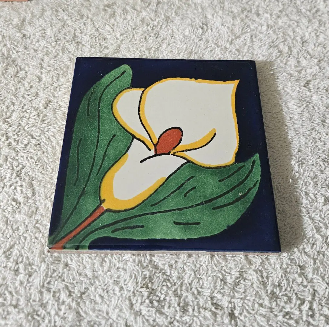 Tile with painted calla lily design.
