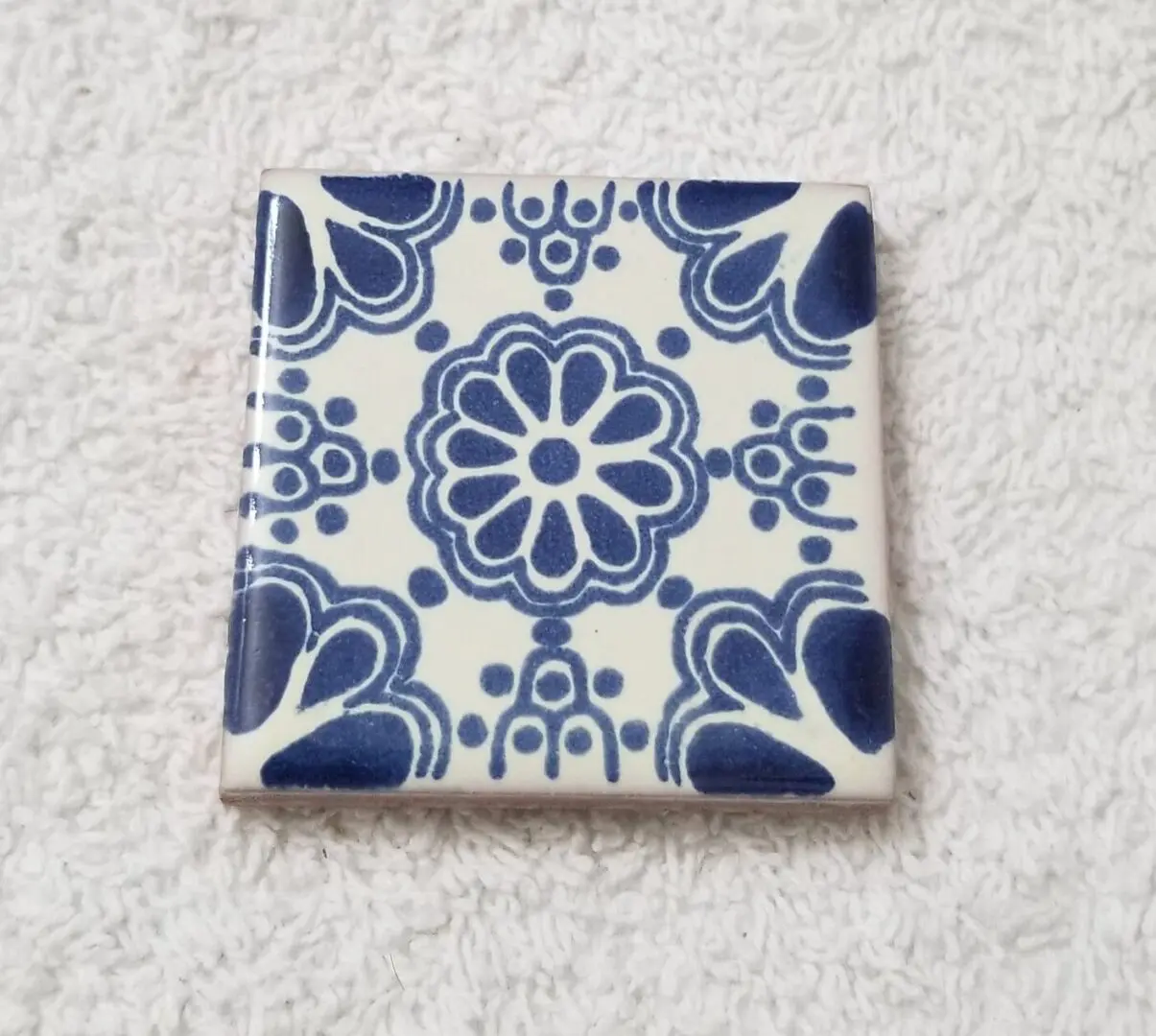 Blue and white ceramic tile with pattern.