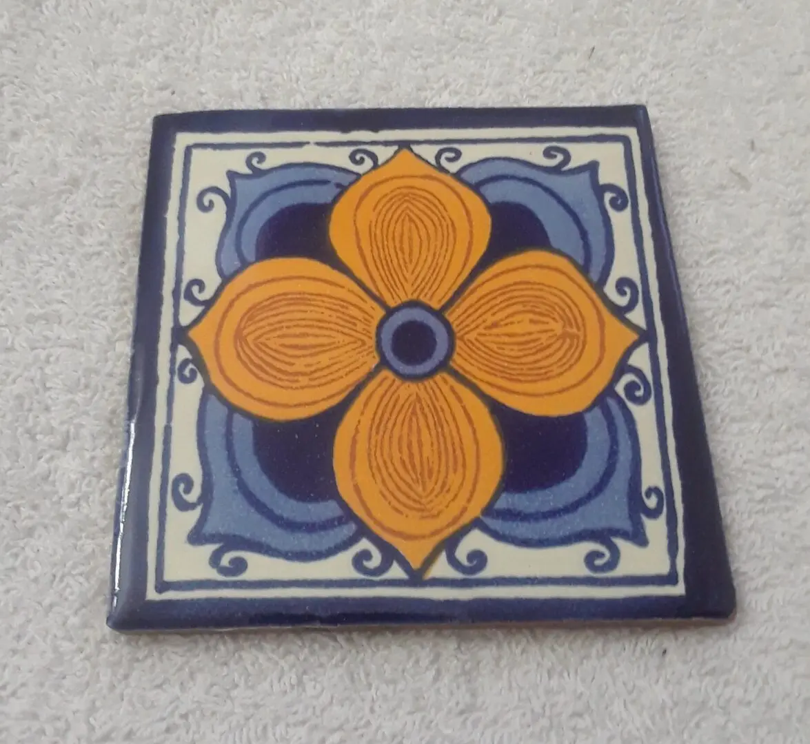 Decorative tile with orange and blue design.