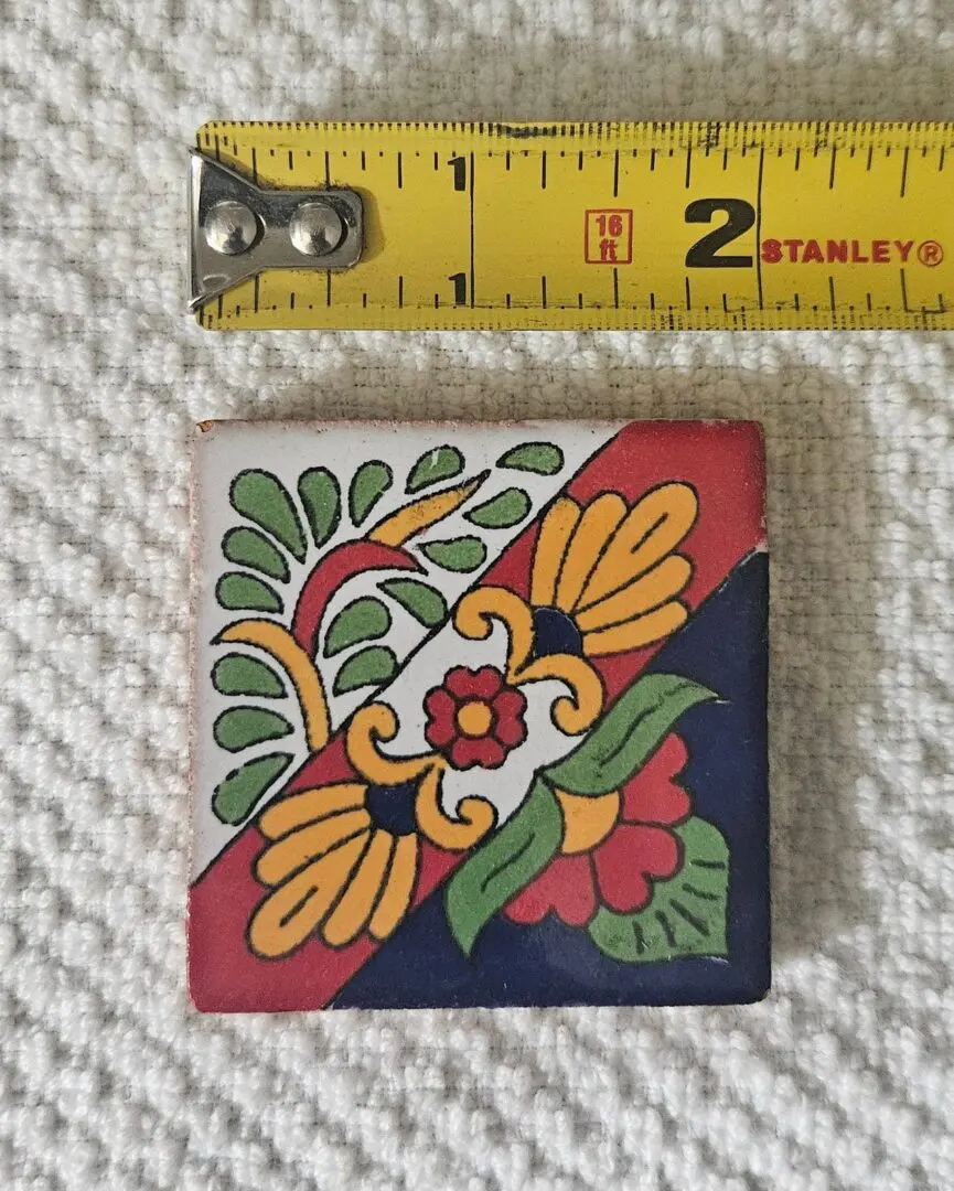 Colorful tile with floral design and ruler.