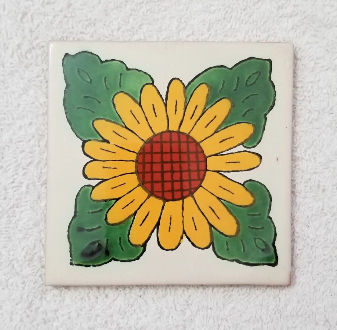Sunflower tile with green leaves design.