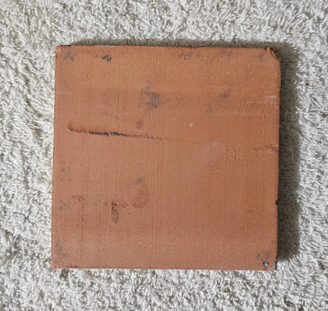 Square terracotta tile on textured carpet