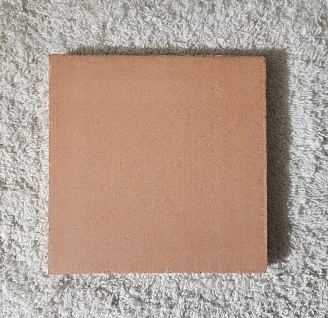 A plain square cardboard box on a textured carpet.