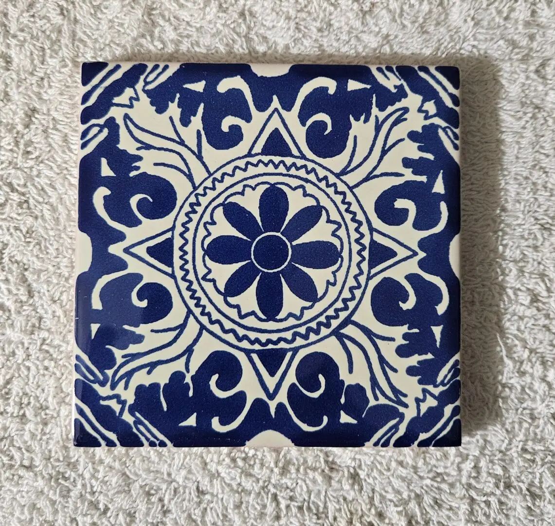 Blue and white decorative tile on fabric.