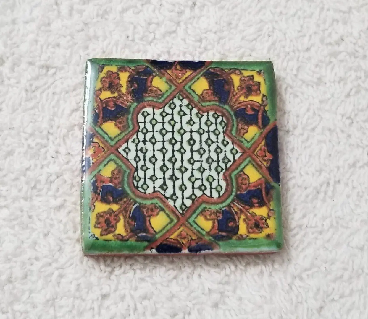 Colorful decorative ceramic tile with intricate patterns.