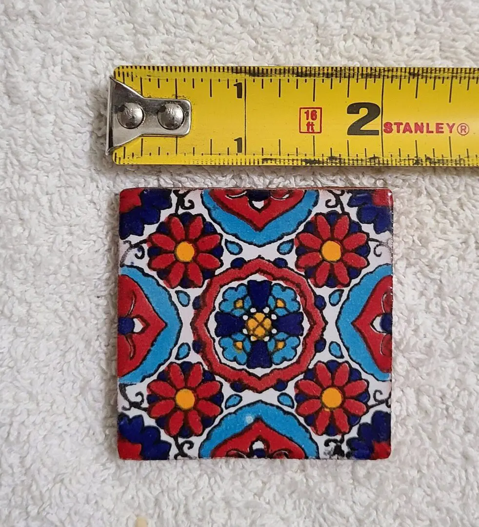 Colorful tile with measuring tape on towel.