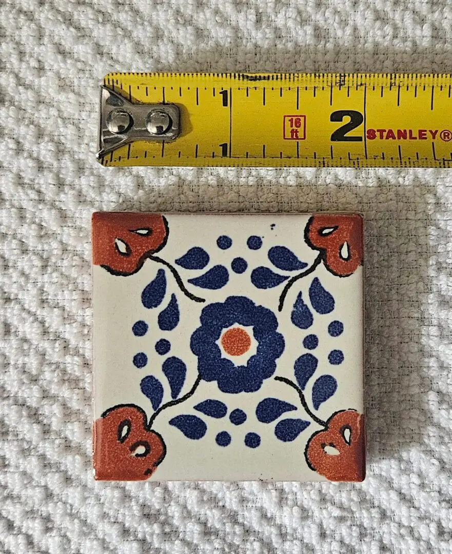 Two-inch decorative ceramic tile with floral motif