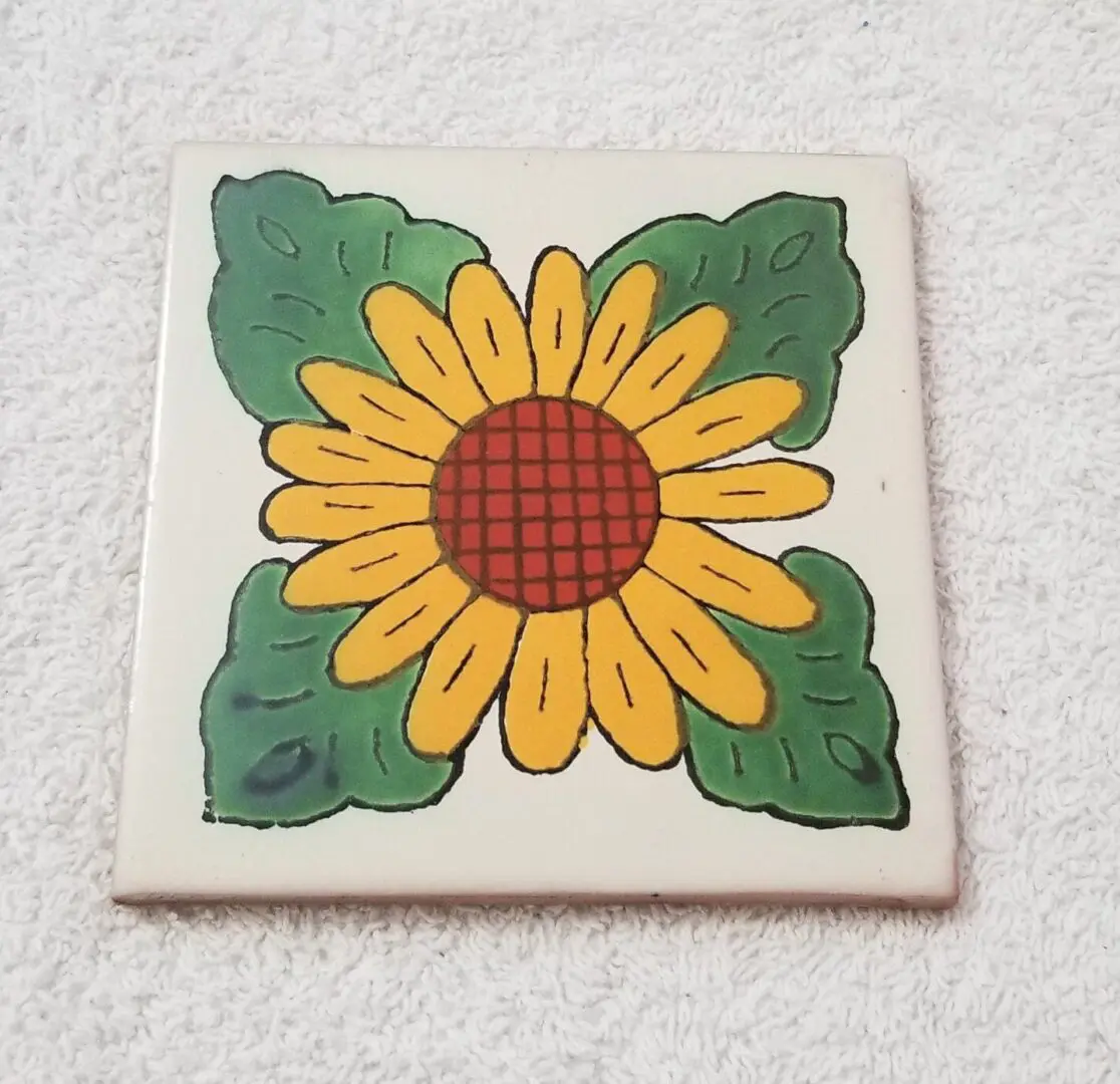 Tile featuring a sunflower with green leaves.