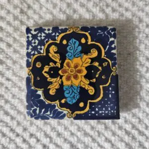 Small fabric square with intricate blue and yellow floral embroidery.