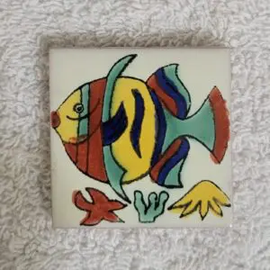 Colorful fish illustration on a small tile with ocean elements.