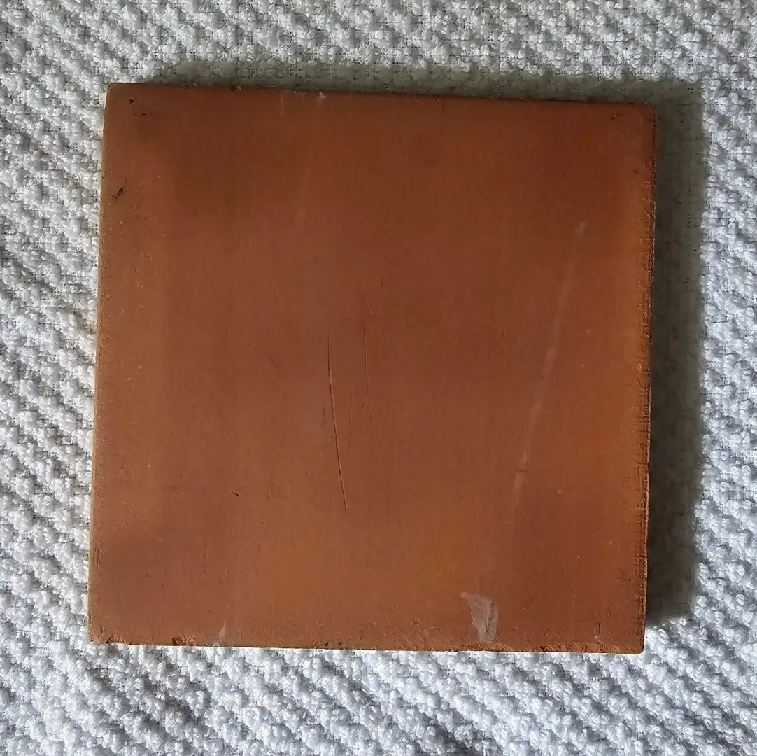 square terracotta tile on textured white fabric