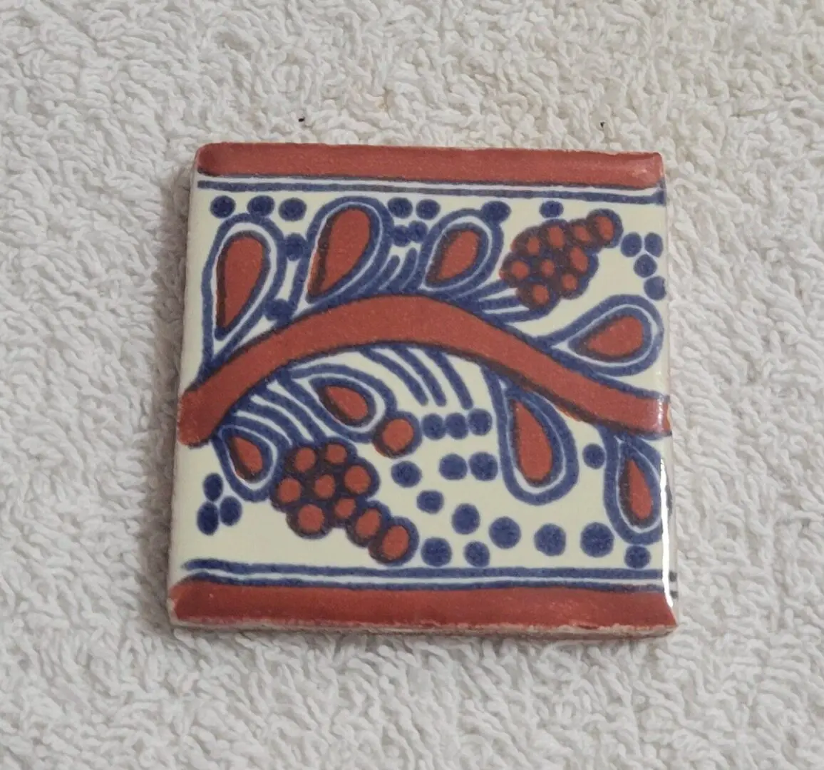 Hand-painted red and blue floral ceramic tile