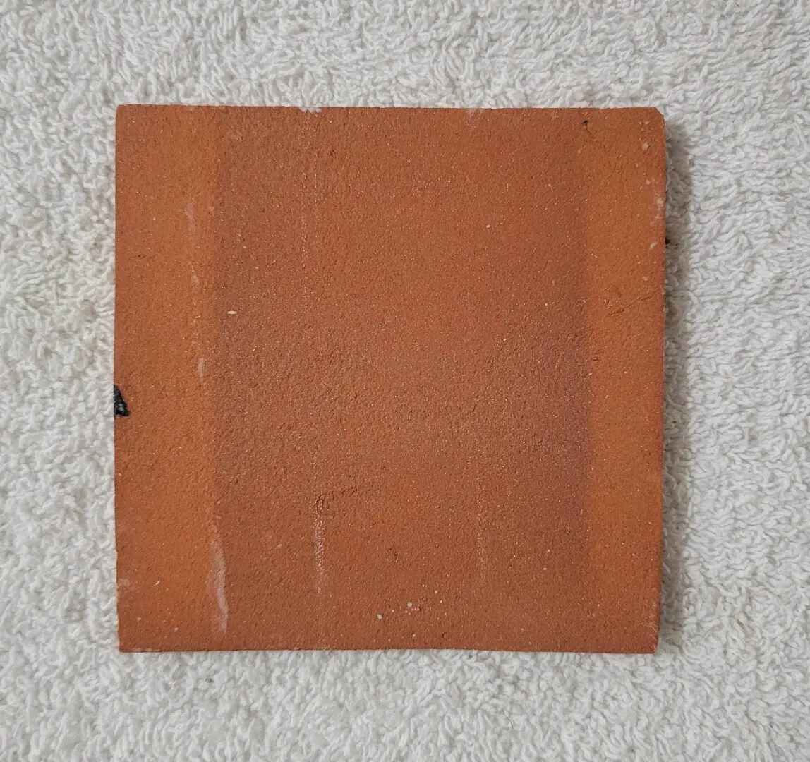 square terracotta tile on white towel