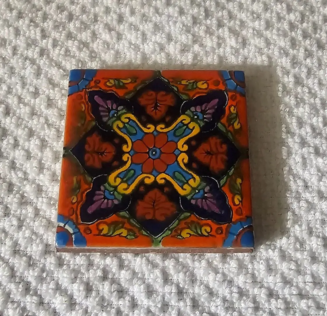 Colorful decorative ceramic tile with intricate floral and geometric patterns.