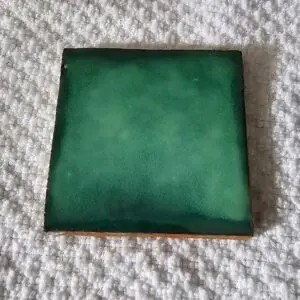 Square green ceramic tile with a slightly worn finish.