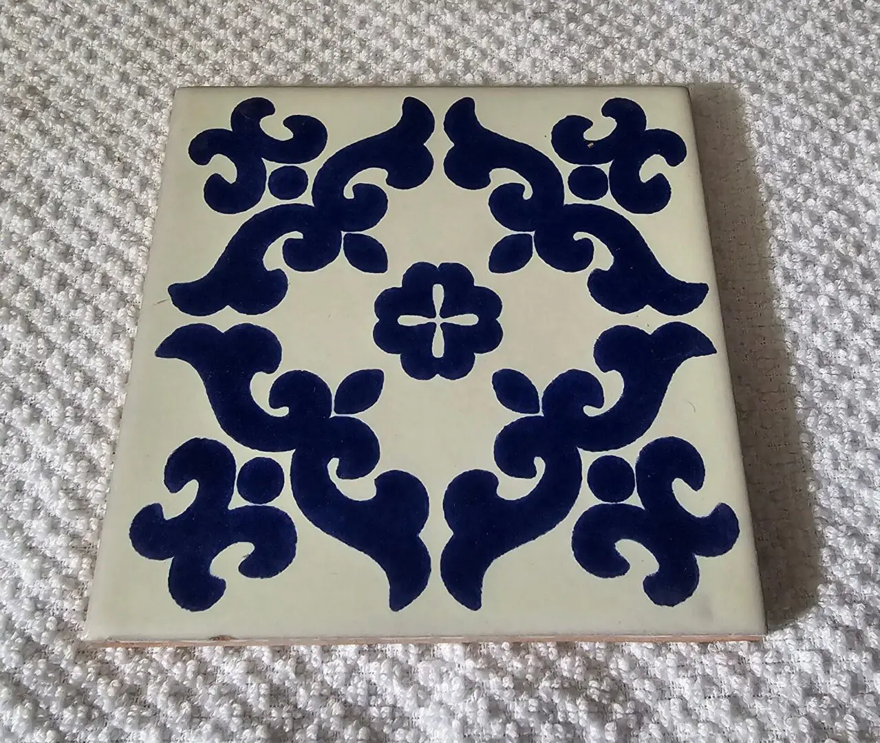 Blue floral pattern on white ceramic tile.