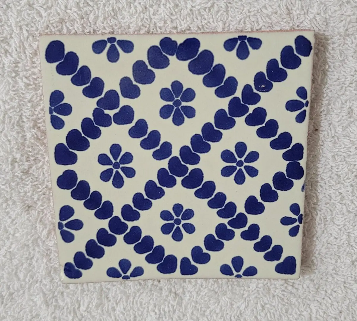 Blue floral pattern on decorative ceramic tile.