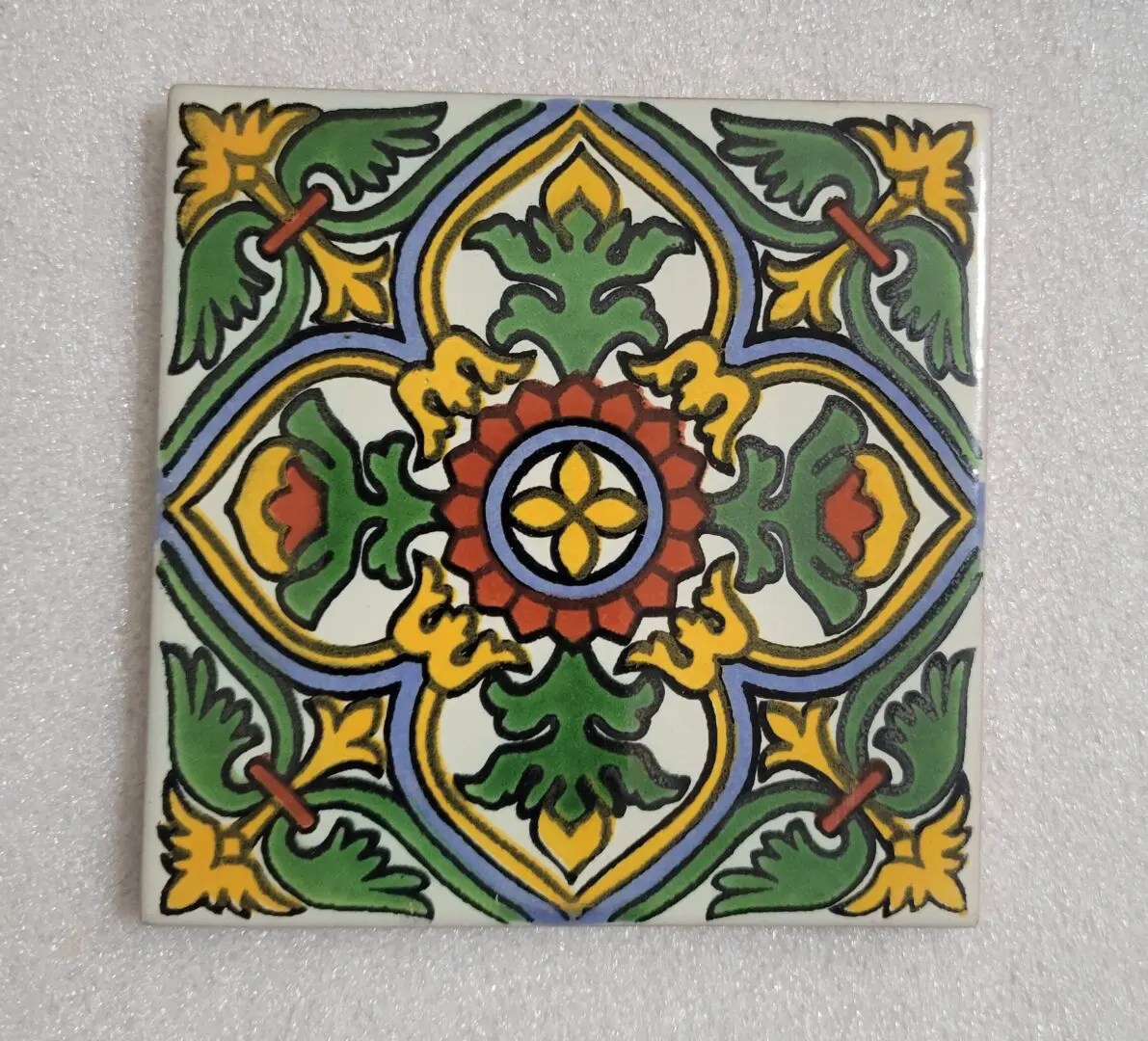Colorful geometric patterned tile with floral motifs.