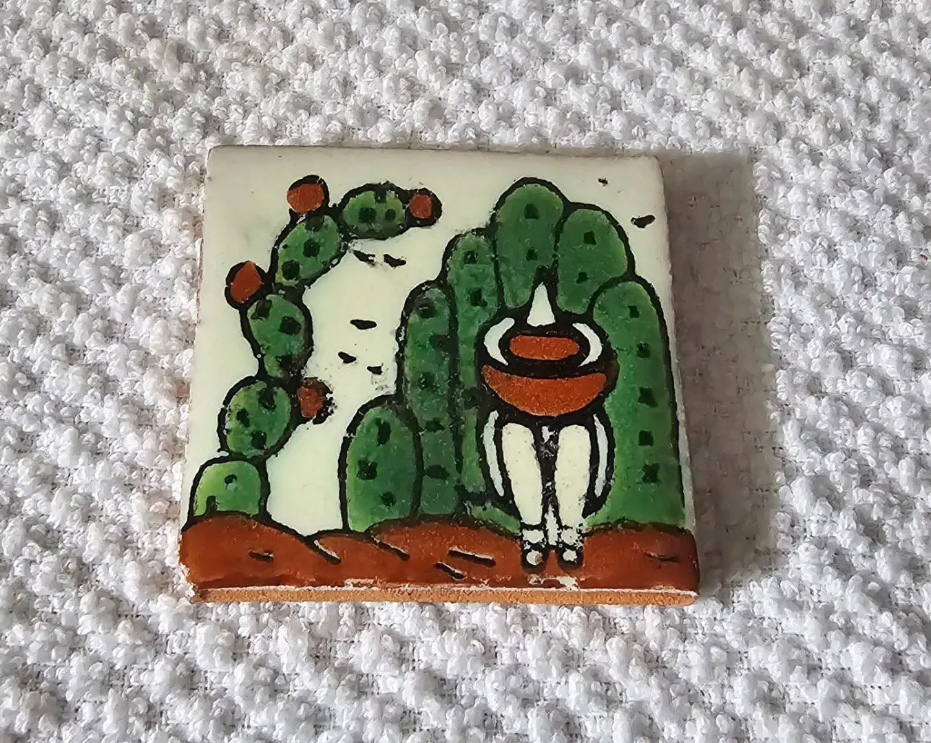 Colorful tile art with cactus and figure.