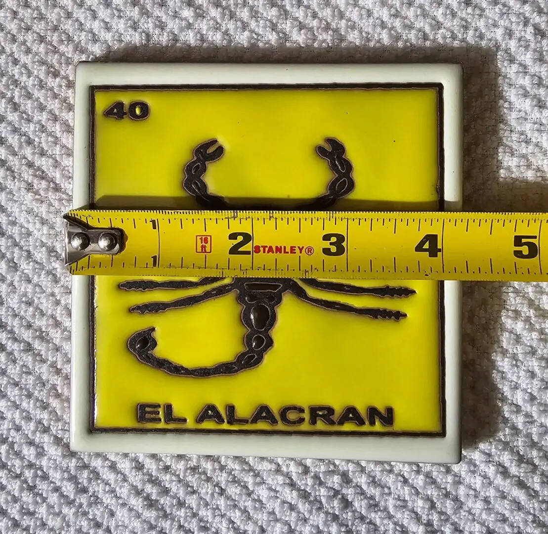 Tile with scorpion image and measuring tape.