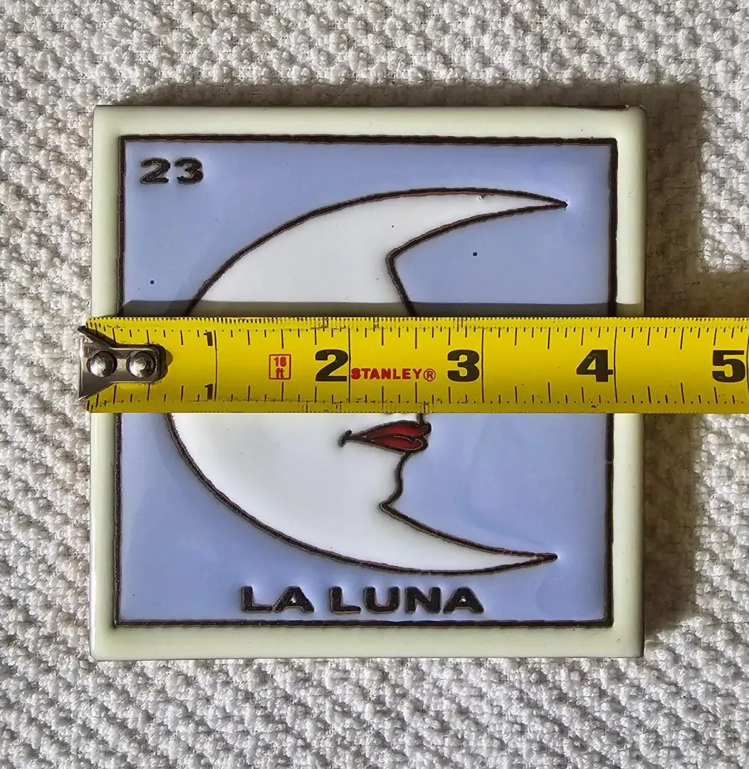 Tile with moon design and measuring tape.