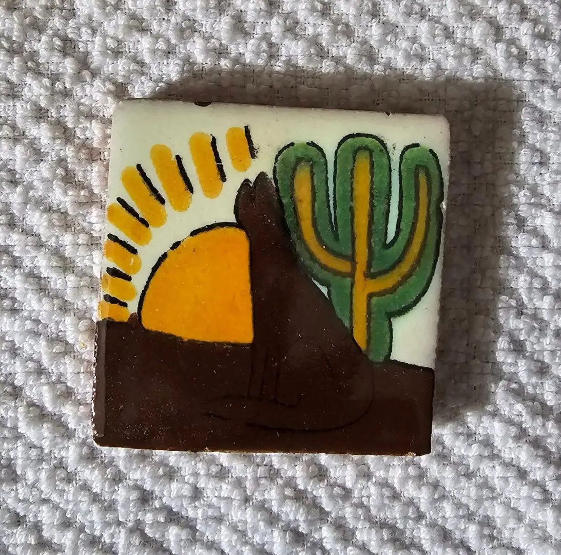 Tile with desert scene, sun, and cactus.