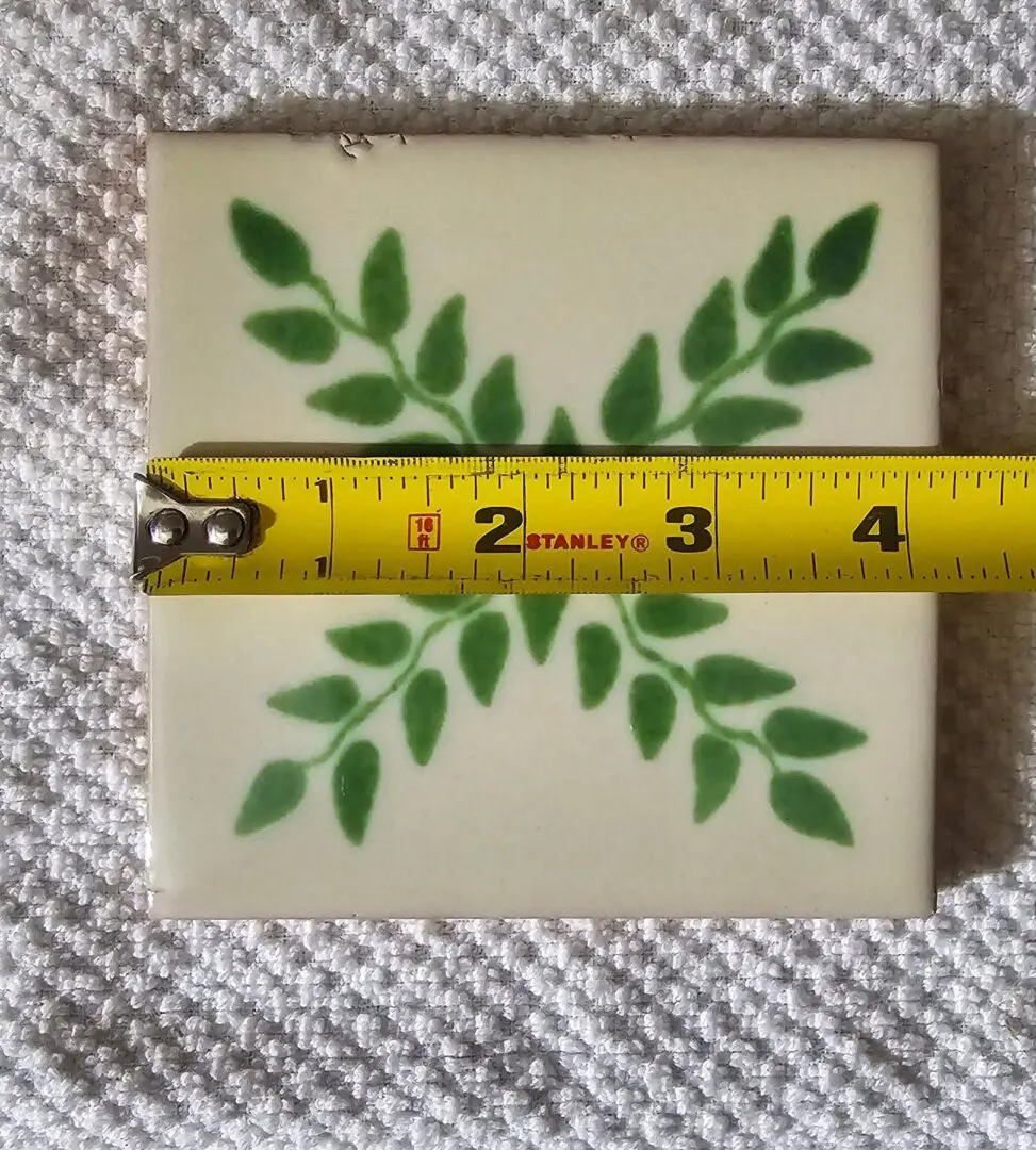 Tile with green leaf pattern and ruler.