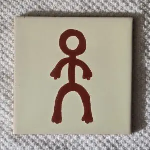 Tile with simple brown stick figure drawing.