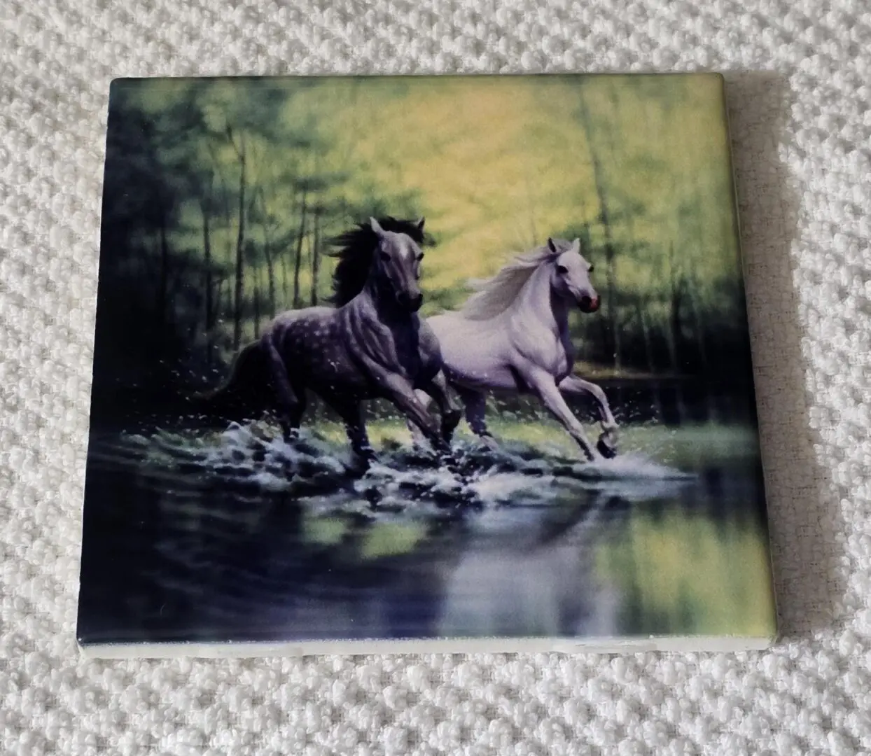 Painting of two horses running through water