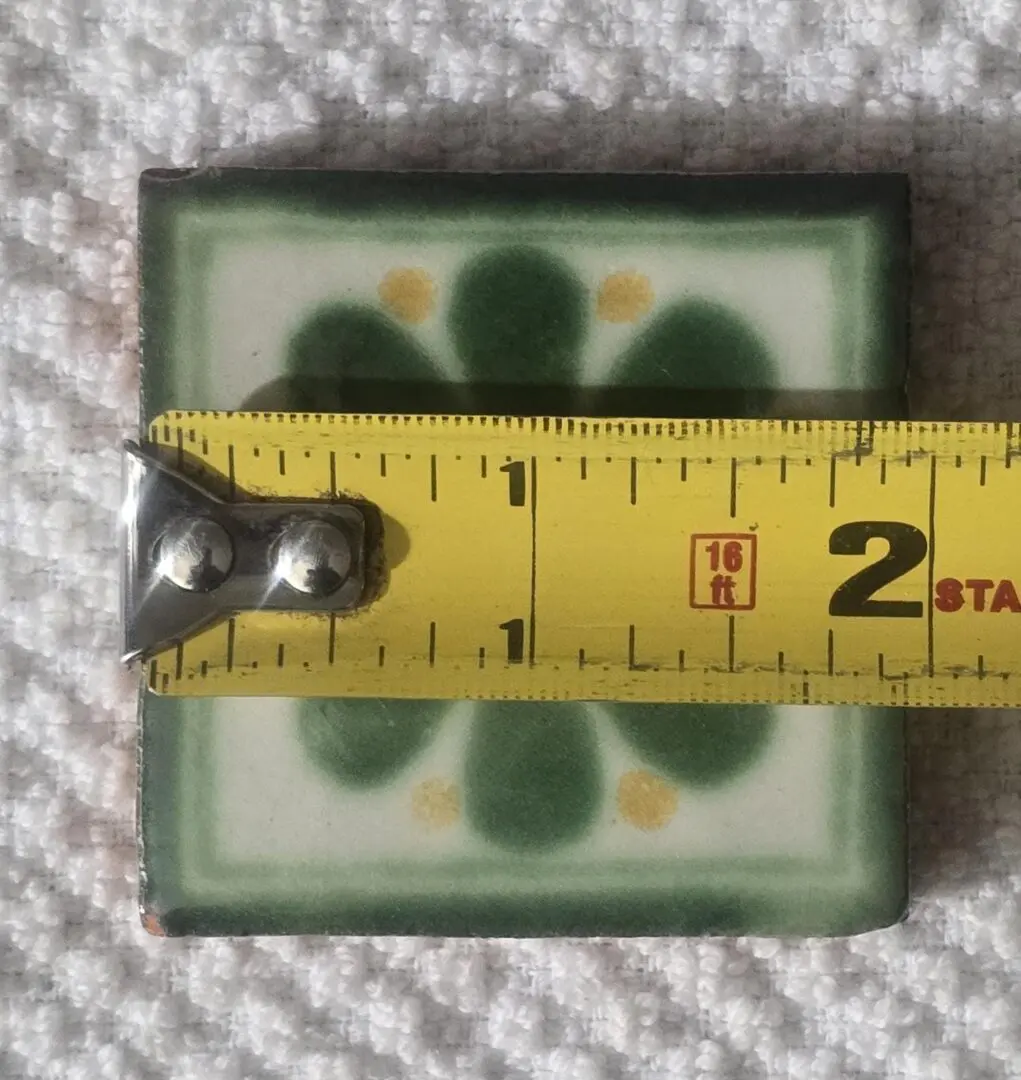 Small square tile with green leaf pattern, about 2 inches wide.