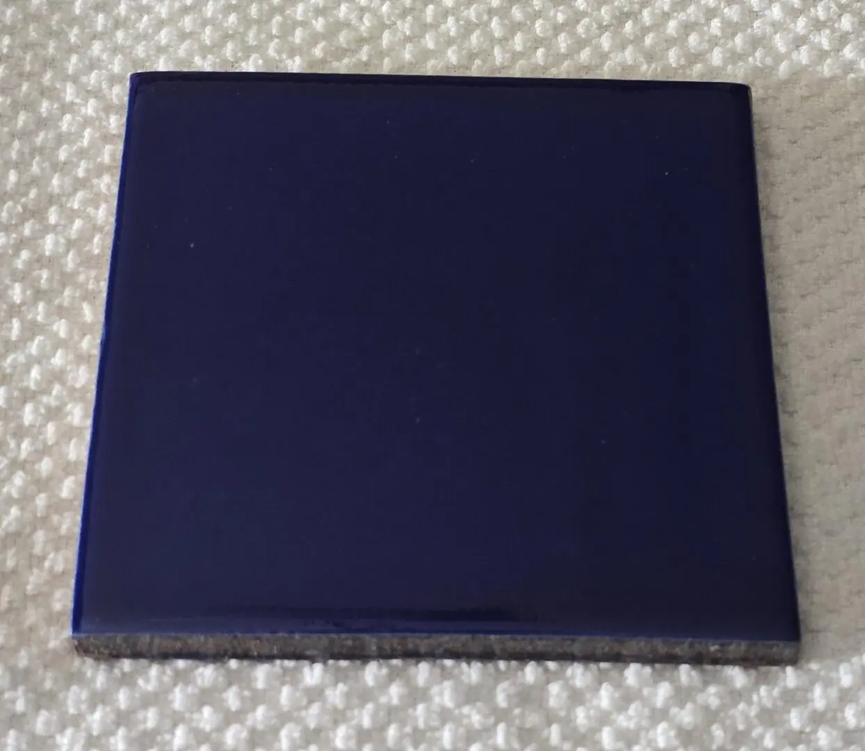 Closed blue square binder on a textured surface.