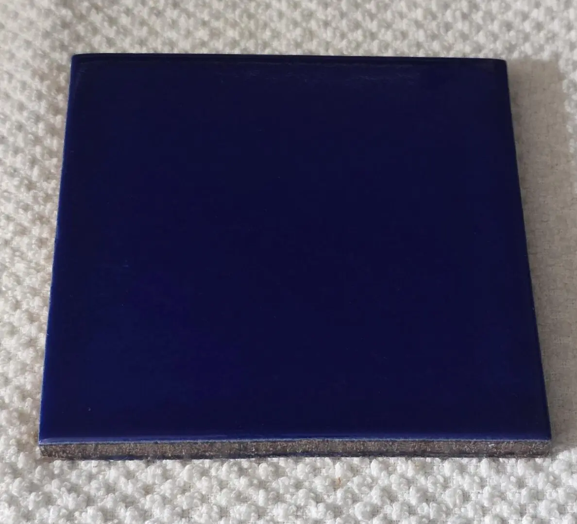A closed, dark blue book on a light surface.
