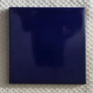 A glossy dark blue square tile with a reflective surface.