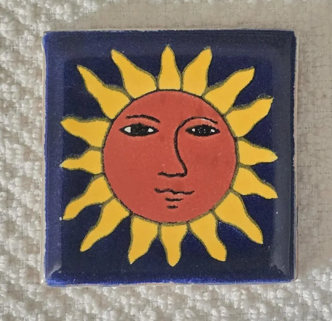 Sunface tile with yellow rays design.
