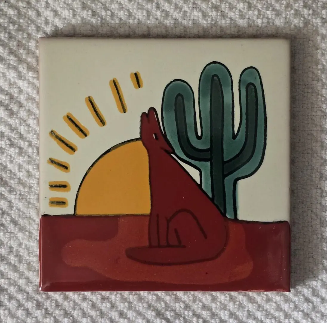 Tile with desert scene: coyote, cactus, and setting sun.