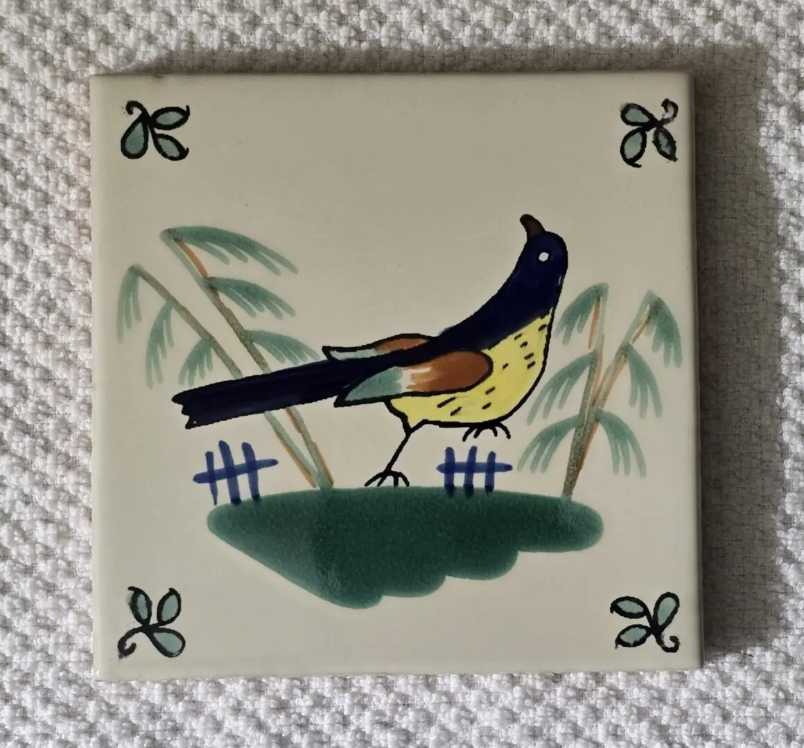 Tile with bird and plant design.